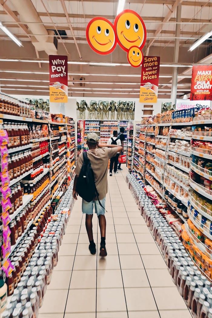 A shopper walks through a colorful grocery store aisle, lively atmosphere.